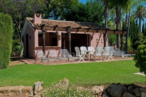 Casa de jardín con tumbonas y vigas de madera